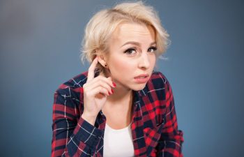 Concerned young woman having difficulty with hearing