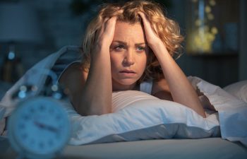 fatigued woman lying awake in her bed in the middle of the night